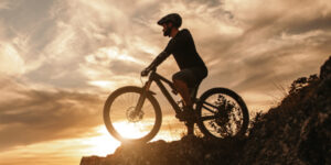 A mountain biker reaches his goal at the top of the mountain.