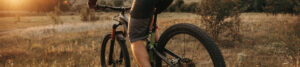 A mountain biker pedals toward the sunset to reach his goal.