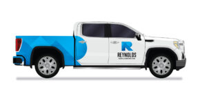 Reynolds Roofing vehicle wrap with blue truck bed and white cab showcasing company logo on the front doors.