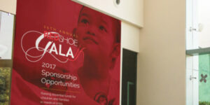 A beautiful charity event banner hangs on a large wall.