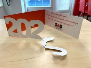 Holiday card show the letters 2020 falling apart when you open it.