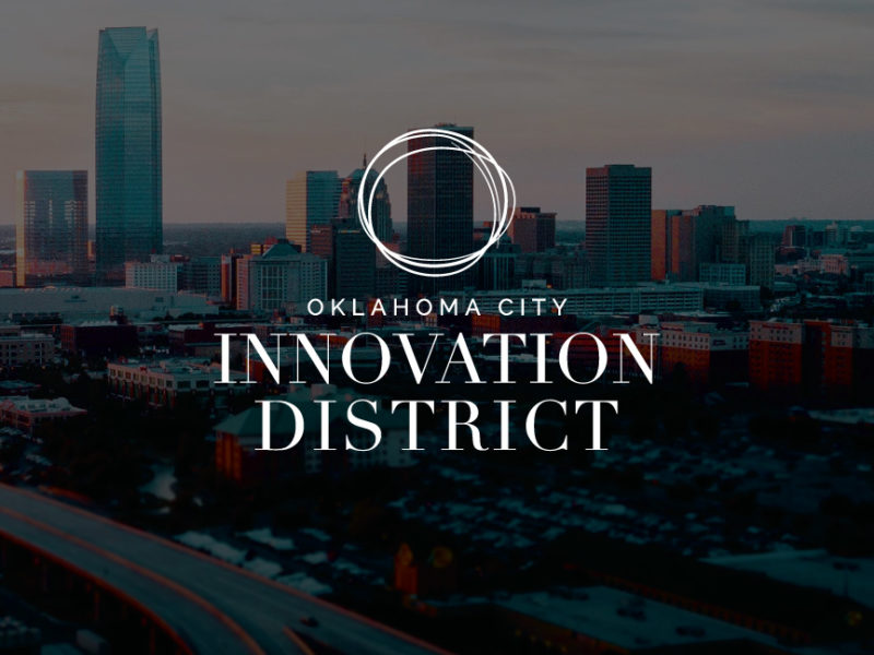 Oklahoma City Innovation District Logo over darkened background image of Oklahoma City skyline