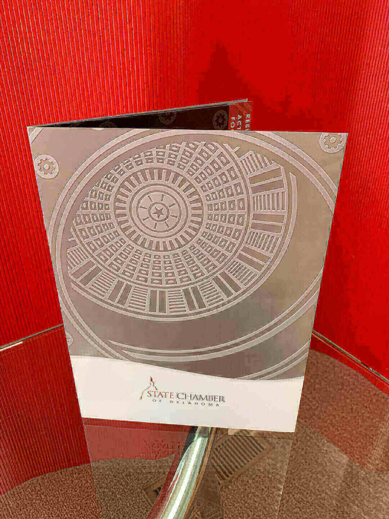 State Chamber of Oklahoma marketing folder uses charcoal grey metallic ink and embossed emblem