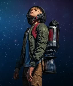 A boy in a jet pack prepares for launch in front of a sky full of stars.